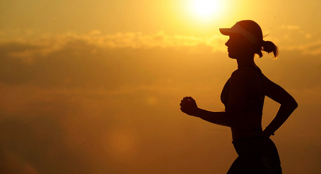 Frau joggt im Sonnenuntergang